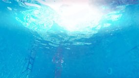 Girl diving in the pool ; Young woman swim and dive in the beautiful swimming pool, underwater video clip.
