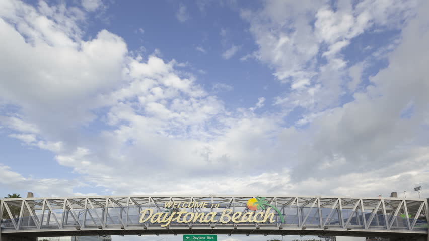 4K Time lapse close up Daytona Beach welcome sign greeting guests to the Florida city with clouds in the blue sky