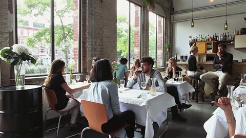 Many Young People Sitting and Talking in Stylish Restaurant
