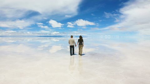 Man and woman walking away on the lake Salar de Uyuni, Bolivia