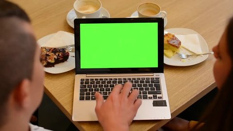 computer (notebook) green screen - woman and man works on computer in cafe - coffee and cake