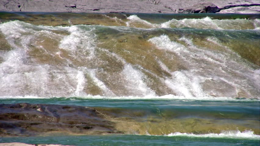 Video zoom out scenic view of waterfalls and river in Pedernales State Park south Texas. Smooth stone river with rapids and flowing water. Rocky forest trees line river. Cool and refreshing. 