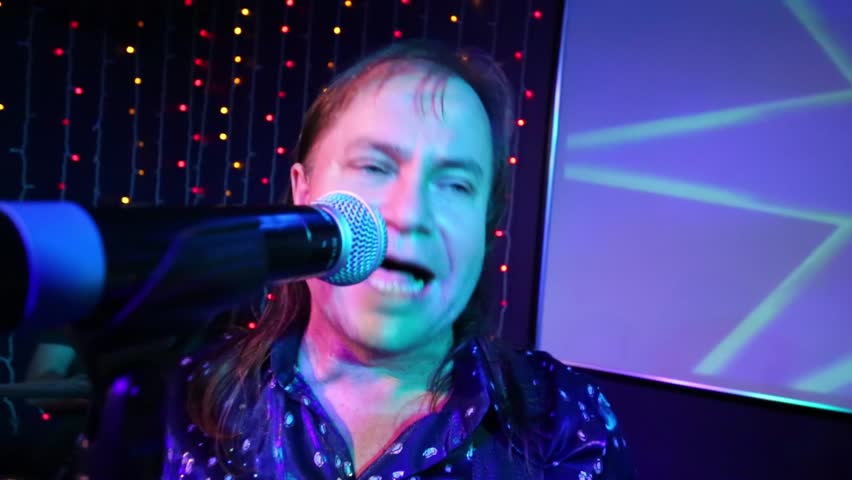 Singer with long hair plays guitar and sings and drummer