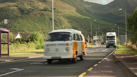 Vintage cars, trucks, cars and cyclist on busy road in scotland