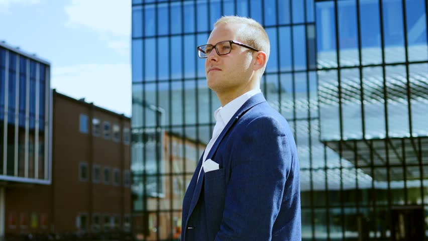 caucasian business man thinking about his future career. modern blue glass building background