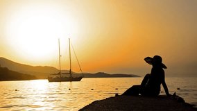 SUMMER CONCEPT, silhouette girl with straw hat watching sunset and boat at sea, wide shoot
