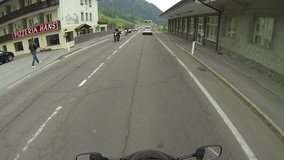 A motorcycle winds their way through Switzerland. A tour of European villages and mountain passes
