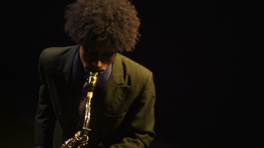 A young saxophonist plays his instrument. 