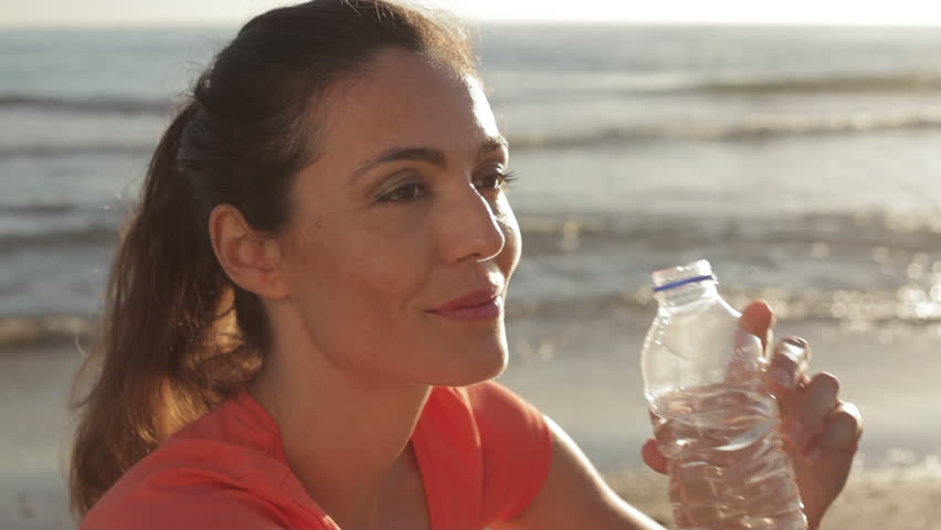 Woman Drinking Water At The Beach In Sunset. | Shutterstock HD Video #8186392