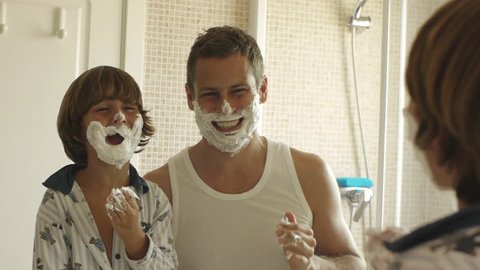 Father And Son With Shaving Cream On Their Faces. Vídeo Stock