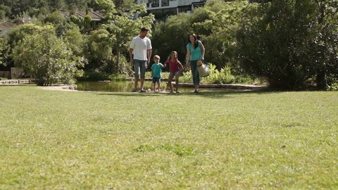 Family Running To Camera In A Park.