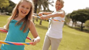 Grandmother And Granddaughter Playing With Hula Hoops In Park. - Powered by Shutterstock - Get 15% off with code: PIKWIZARD15