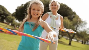 Grandmother And Granddaughter Playing With Hula Hoops In Park. - Powered by Shutterstock - Get 15% off with code: PIKWIZARD15