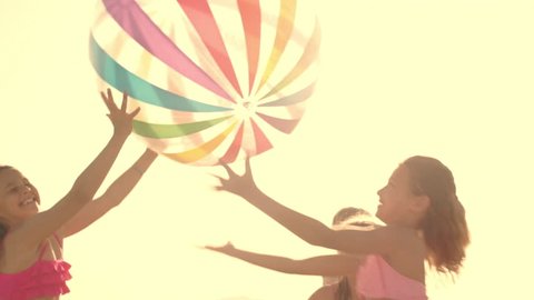 Slow-Motion Of Five Children Playing With Beach Ball On Beach.