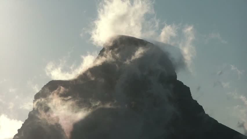 Peak of a mountain surrounded by clouds giving a boiling steamy impression. The mountain is called Lion