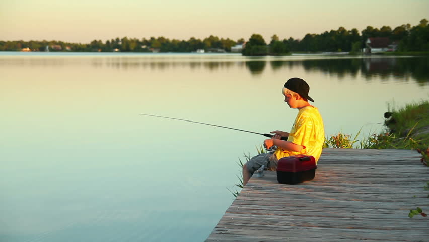 A young boy fishes in the early evening.
