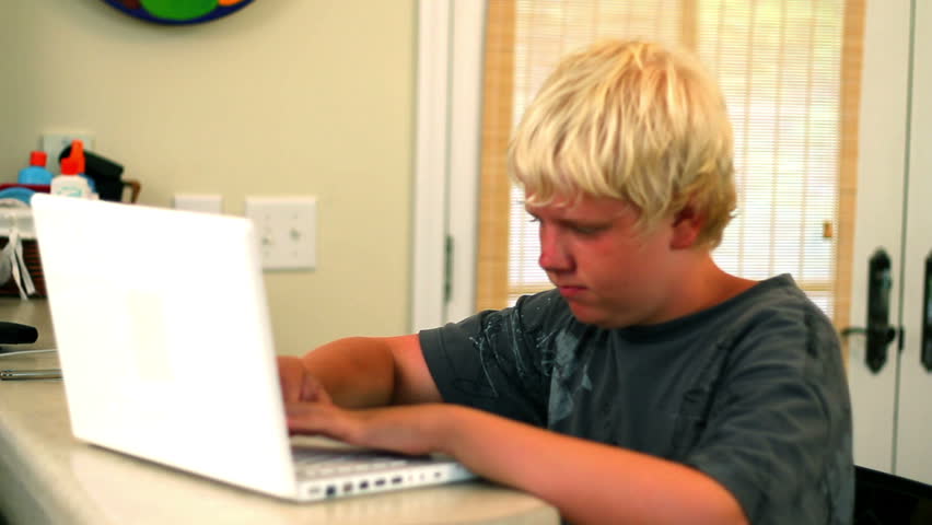 A young boy uses his laptop.