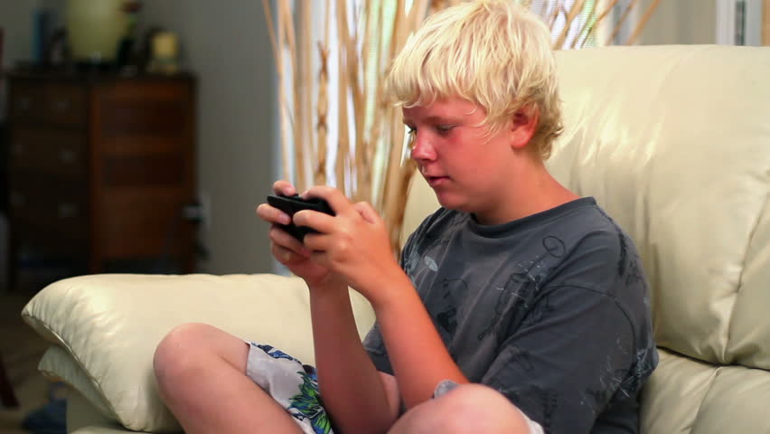 A young boy plays a handheld video game.