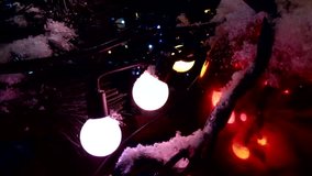 Christmas illumination. Snowy fir tree at night and lights. New Year celebratory video.