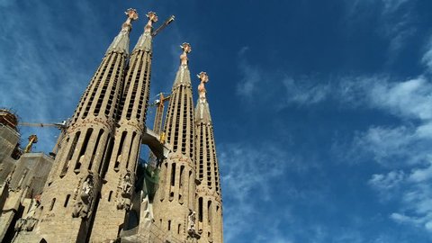 Time-lapse clouds over towering spires of Sagrada Familia church in Barcelona, Spain