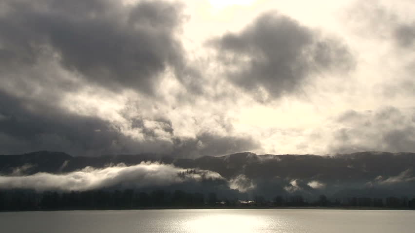 Time lapse while large storm system develops over forest landscape and river in the Pacific Northwest, USA.