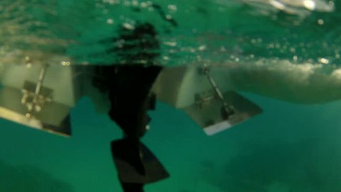 Underwater shot of propeller of outboard engine starting
