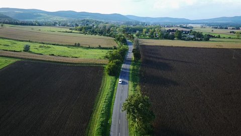 White limousine passing by. Top view recorded by drone from the sky.
