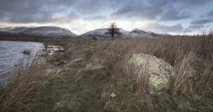 4K Motion timelapse sequence and HD video clip of a wintry December sky over the snowy mountains of Blencathra & Skiddaw, Lake District, Cumbria, UK with Tewet Tarn in the foreground
