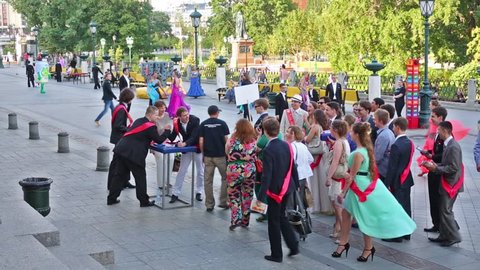 MOSCOW, RUSSIA - JUN 23, 2013: Crowd is watching how graduates are arm wrestling on the street at Graduate-2013.