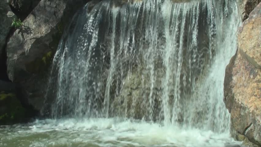 Waterfall flowing through rocks in Chicago Botanic Garden.