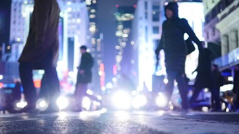pedestrians crossing crosswalk in city at night. new york city street background