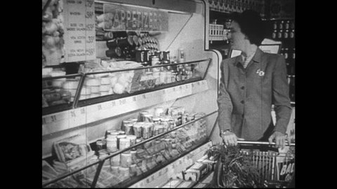 UNITED STATES 1950s : Housewife shopping for groceries at supermaket. A woman's hand selects bacon and milk. Housewife at supermarket checkout. She counts out money as cashier rings up groceries