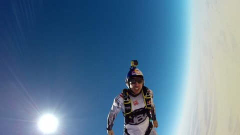 A skydiver high fives another skydiver while skydiving in the sky, makes various hand signs while skydiving, POV