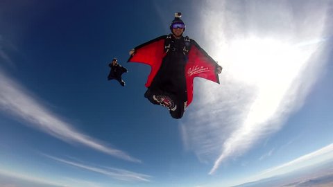 A group of skydivers in wingsuits gliding in the air, POV