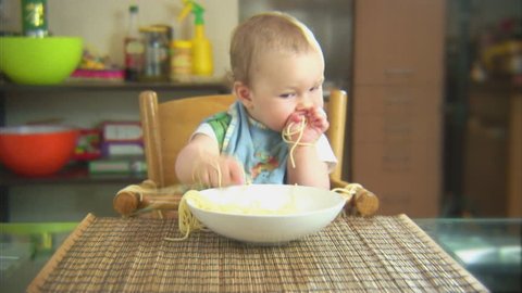 Funny child playing with spaghetti and sauce. Scene 2