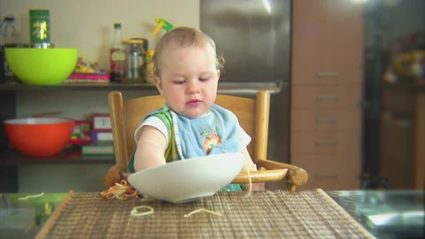 Funny child playing with spaghetti and sauce. Scene 5
