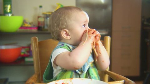 Funny child playing with spaghetti and sauce. Scene 6