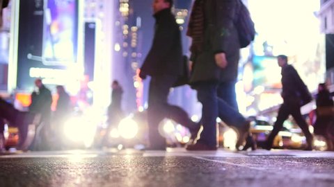 people crossing street of new york city at night. pedestrians walking on public street