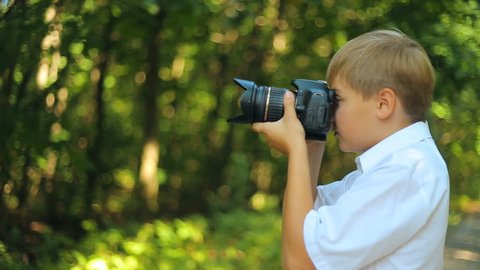 boy takes pictures and views photos on DSLR camera. Childhood dreams and memories. Forest Nature and  animals protection, Ecology of Earth and environment, clean fresh air