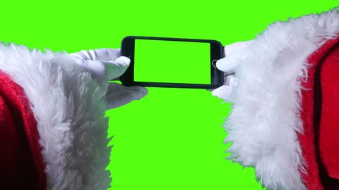A close up shot of Santa Claus using a green screen smartphone. With optional luma matte.