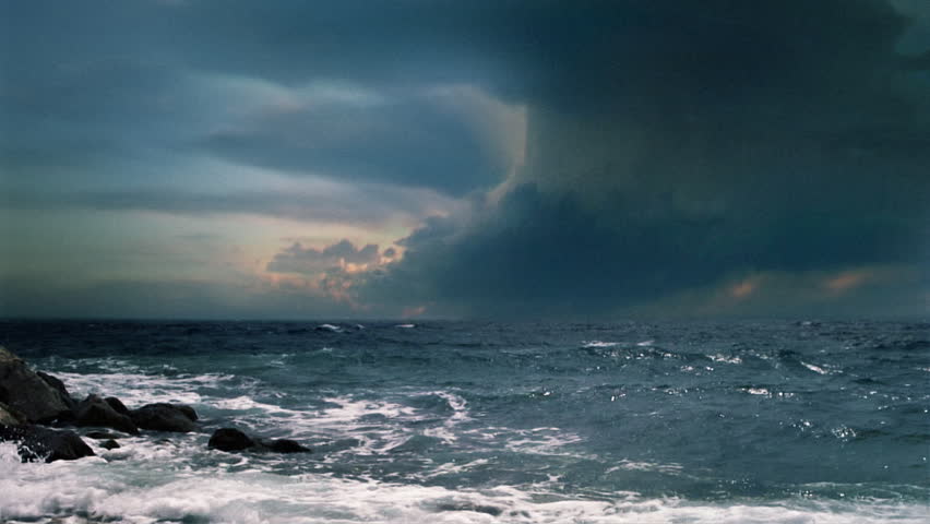 Cinematic storm clouds with lightning strikes reflecting in ocean.