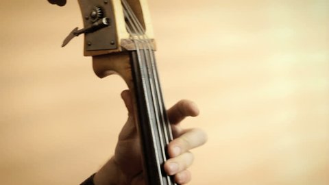 Musician playing upright bass old jazz instrument closeup