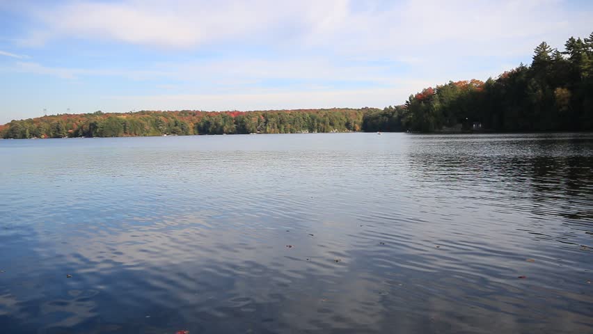 Autumn lake with a paddler in a distance in Cottage County of Ontario, Canada