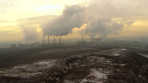 Polluting factory at dawn, aerial vew, near the dump