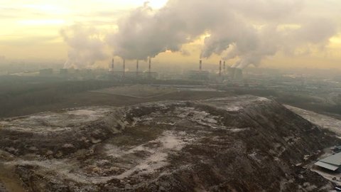 Polluting factory at dawn,aerial vew, near the dump
