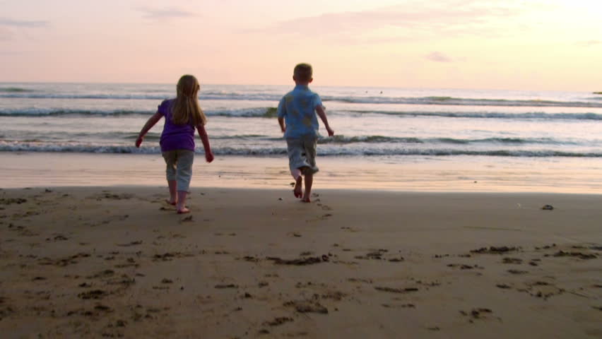 two children run along the shore. 