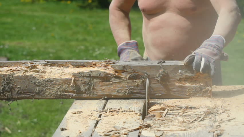 Man cutting wood with circular saw.  Woodworking in garden.