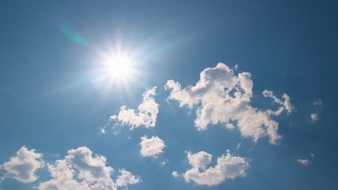White clouds flying on blue sky with sun rays - Time-lapse motion background
