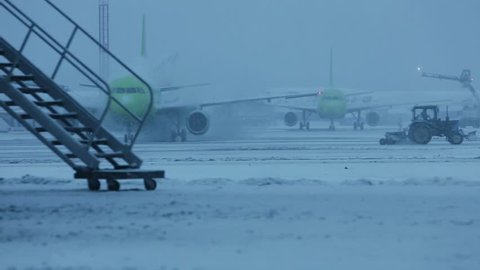 Snowstorm at the airport. Preparation protective treatment of aircraft icing
