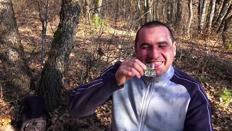 Man drinking whiskey brandy with emotion in forest picnic. Sony 4K steadycam slow motion shot stock video